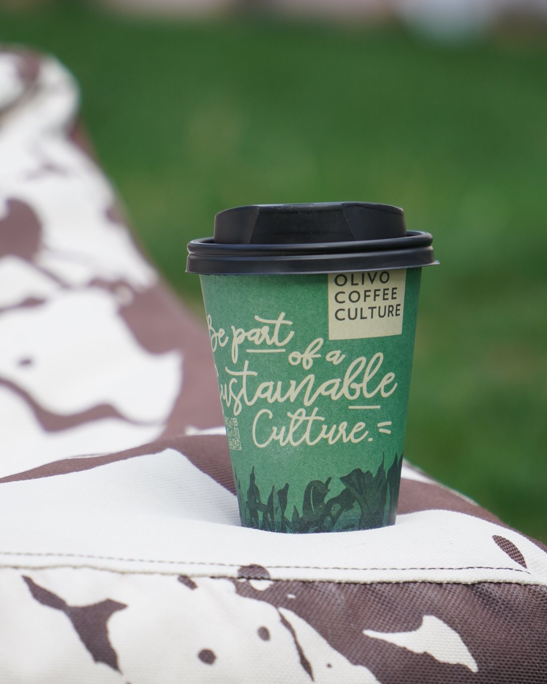 Pahar de cafea reutilizabil Olivo Coffee Culture, pe fundal verde